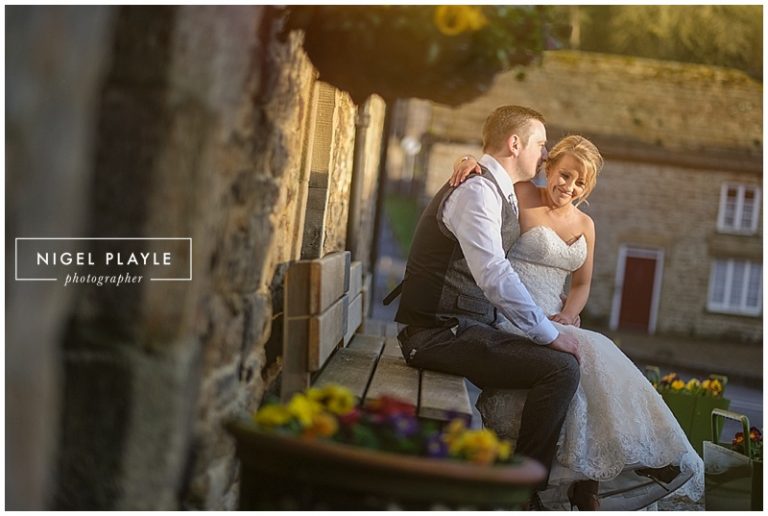 A **wedding** bride and groom sitting on the steps of a building.