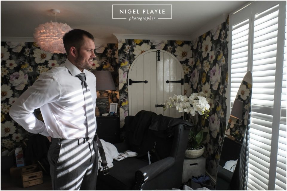 groom putting on tie