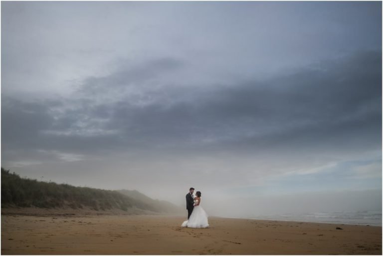 Bride and groom on beach at Newton Hall