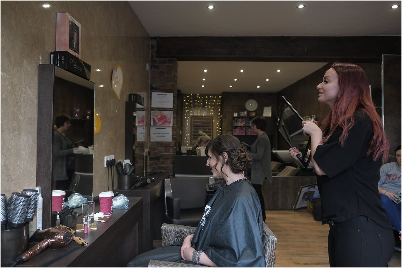 A woman is getting her hair done for her wedding in a salon.