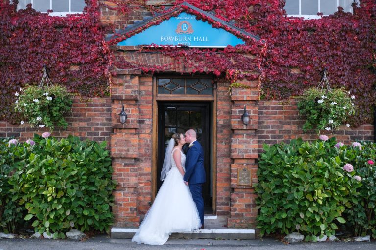 bride and groom kissing in doorway