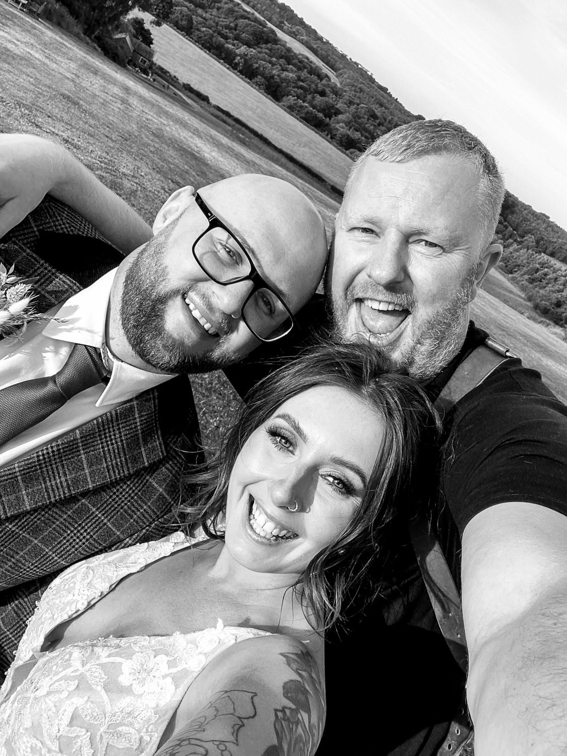 A black and white wedding photograph of a man and woman taking a selfie.
